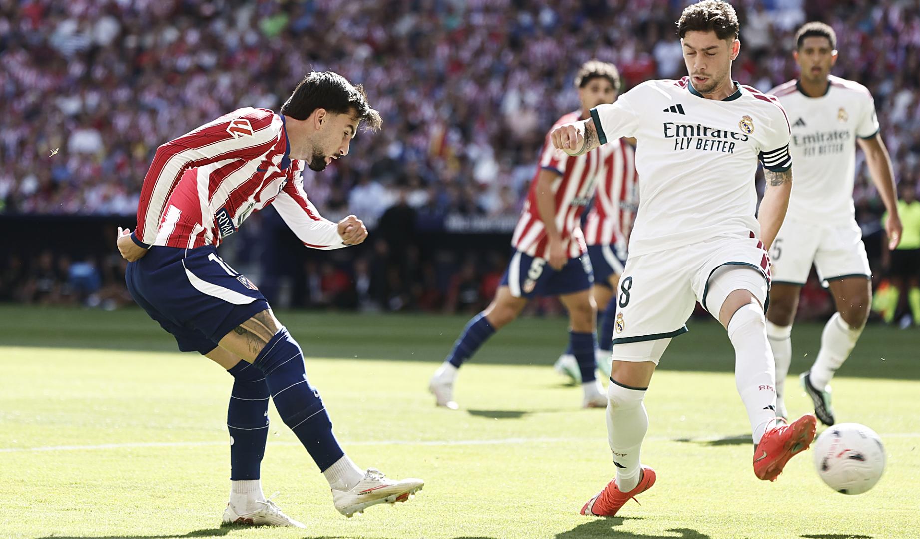 Fede Valverde trata de tapar el disparo de Álex Baena durante el derbi en el Metropolitano