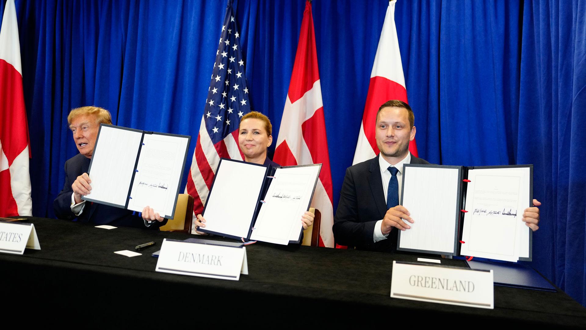 El presidente de Estados Unidos, Donald Trump, la primera ministra de Dinamarca, Mette Frederiksen, y el primer ministro de Groenlandia, Jens-Frederik Nielsen, muestran los documentos firmados durante la ceremonia de firma de un acuerdo trilateral de seguridad en el Ártico