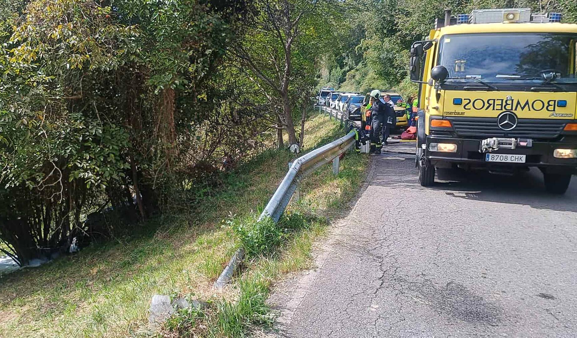 Bomberos de Llanes trabajan en el lugar en el que se salió de la vía el automóvil