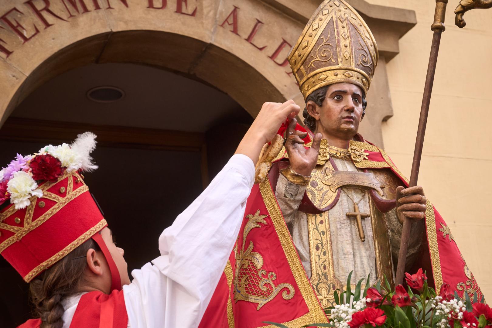 Un dantzante coloca el dulce en las manos de San Fermín de Aldapa o San Fermín Txikito