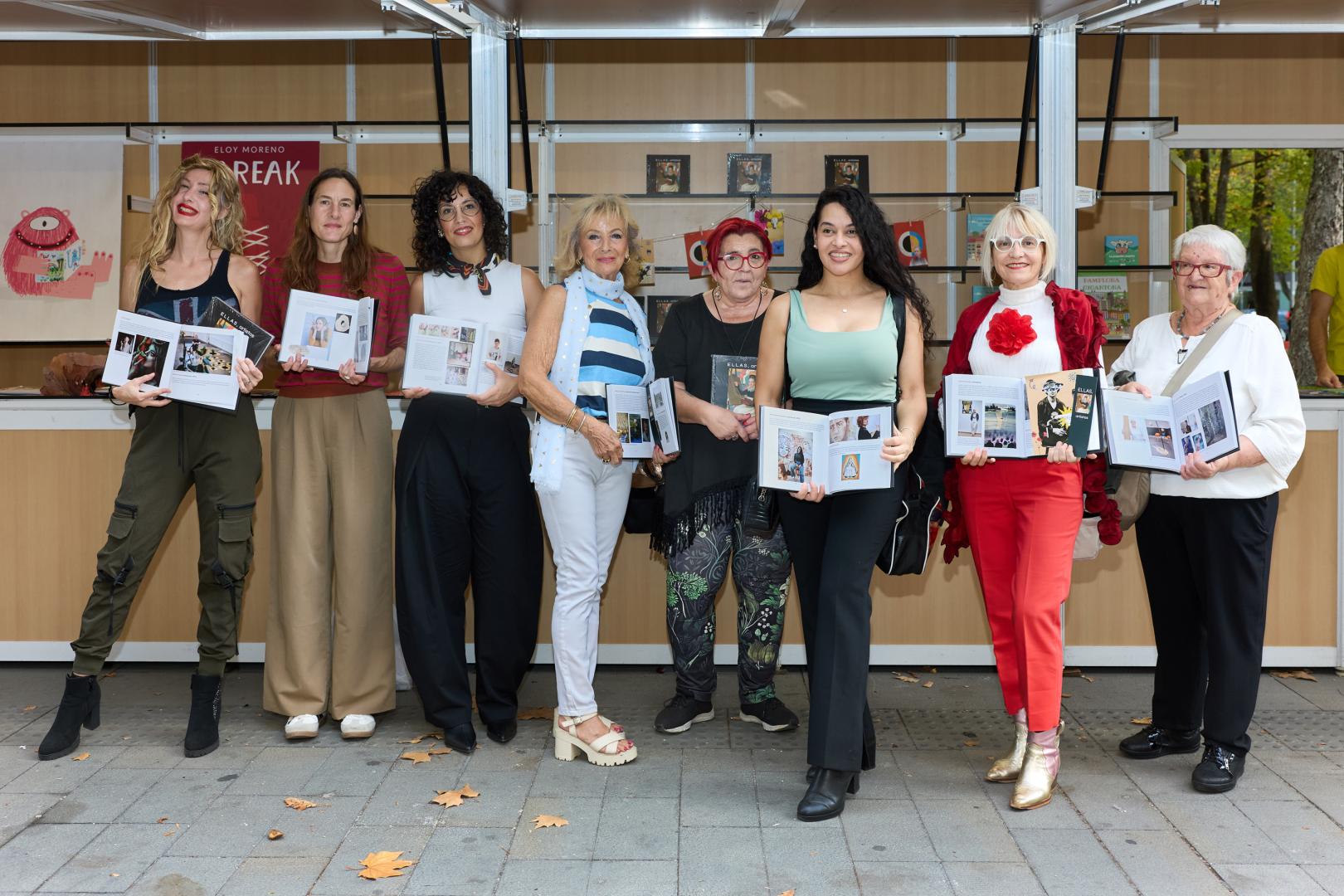 Desde la izq: Silvia Catalán, Ainhoa Sánchez, Sandra Nadal, Pilar García Escribano, María Jesús Castillejo, Delia Izabel Hinestroza, Conchi Ororbia y Mertxe Sueskun muestran ejemplares del libro junto a la caseta de la autora en la Feria Editargi.