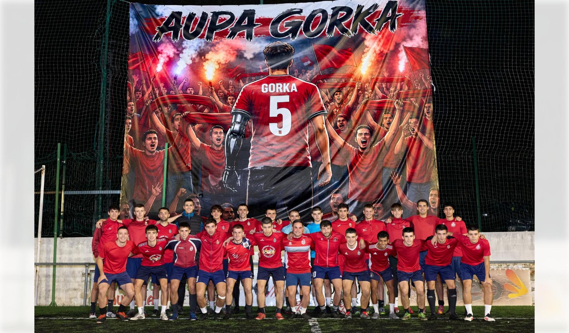 La plantilla y el cuerpo técnico del Baztan posan delante de la pancarta en homenaje al joven Gorka Goñi