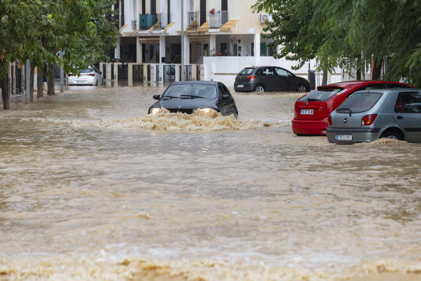 Un coche circula por una calle inundada de Los Alcázares, (Murcia)