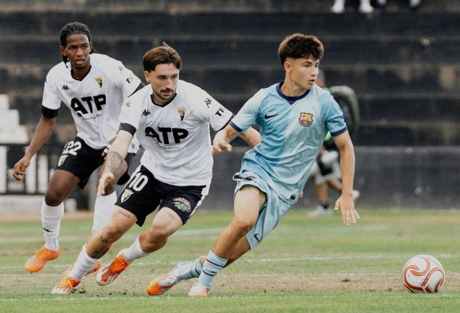 Argemi, del Barcelona B, conduce el balón ante Ekhi, del Tudelano. Detrás sigue la jugada Zaka.