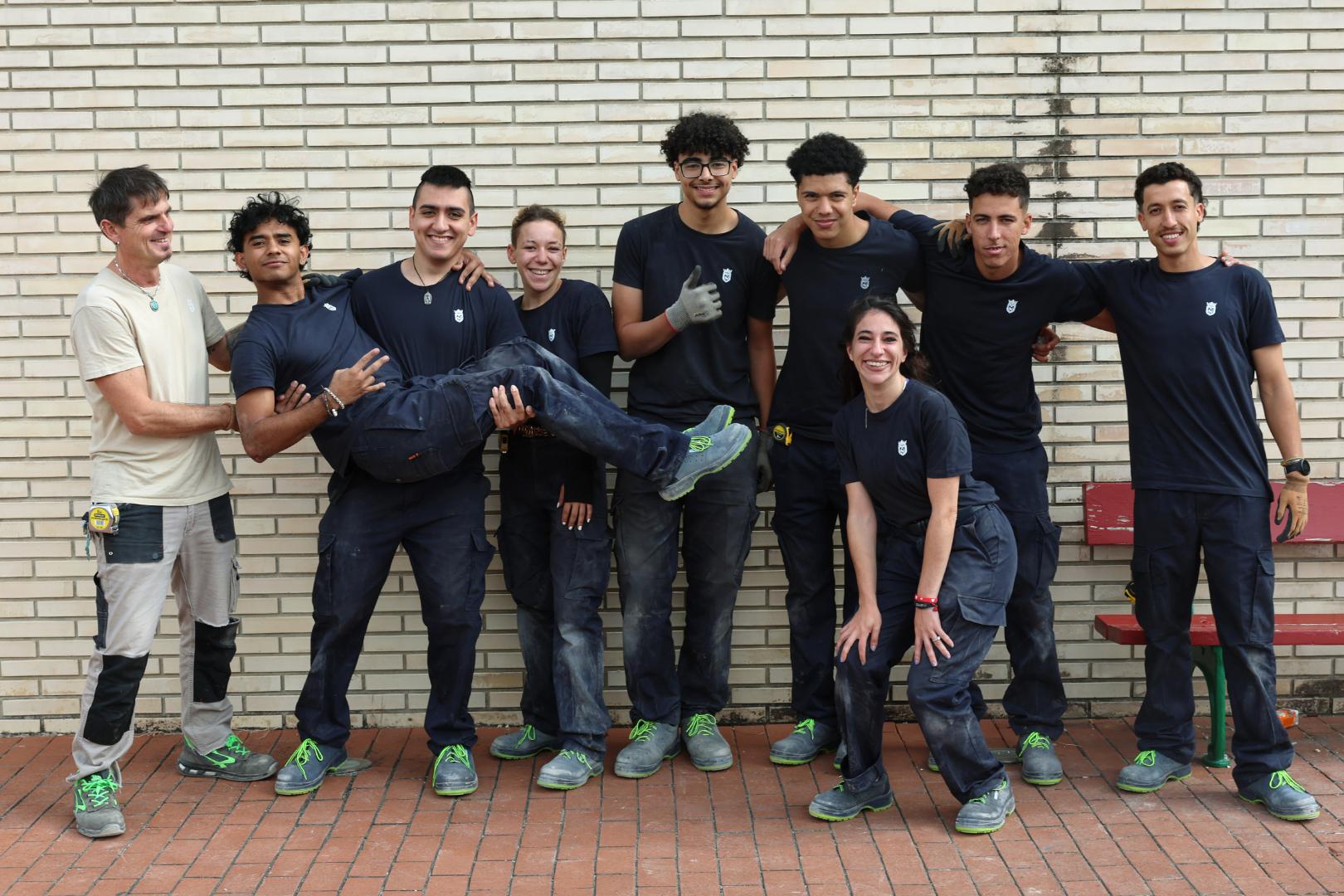 Alumnos de la escuela taller de albañilería en el descanso de la mañana, con uno de sus monitores.