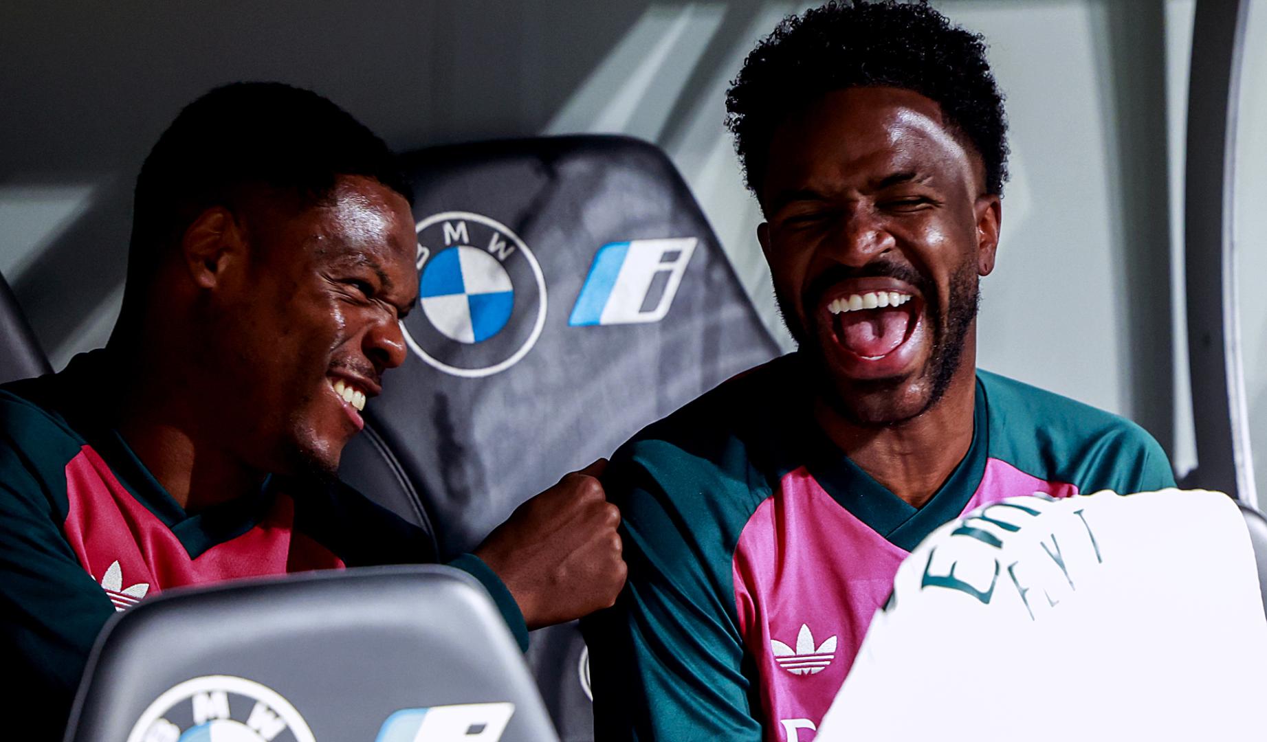 El delantero del Real Madrid Vinicius Junior sonríe junto a su compañero, Denzel Dumfries, en el banquillo durante el encuentro contra el Villarreal