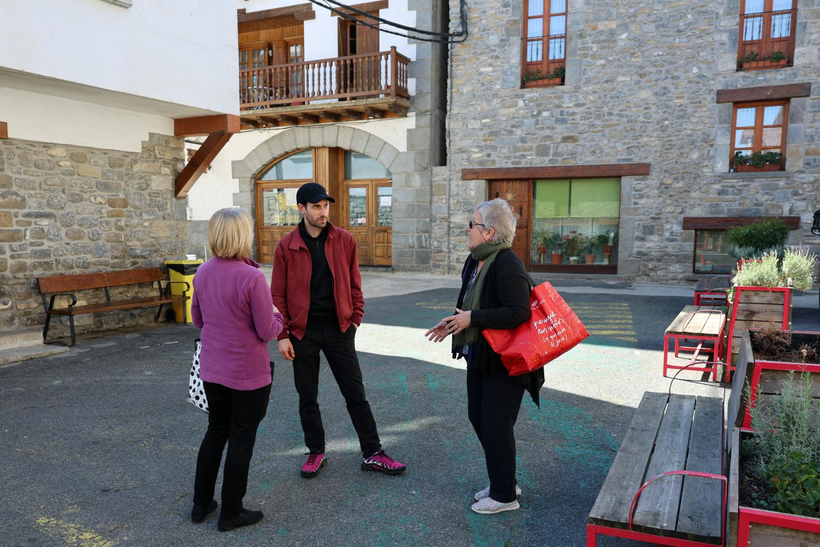 Dos vecinas conversan con el alcalde, Flavien Paget, en la plaza Padre Tomás de Burgui