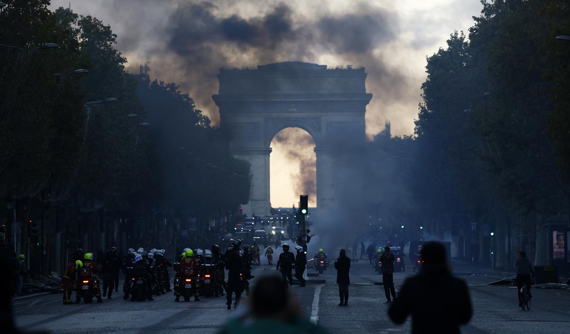 Agentes de policía se enfrentan a manifestantes durante una protesta contra el aumento del costo de vida y los recortes en los servicios públicos en los Campos Elíseos, en París.