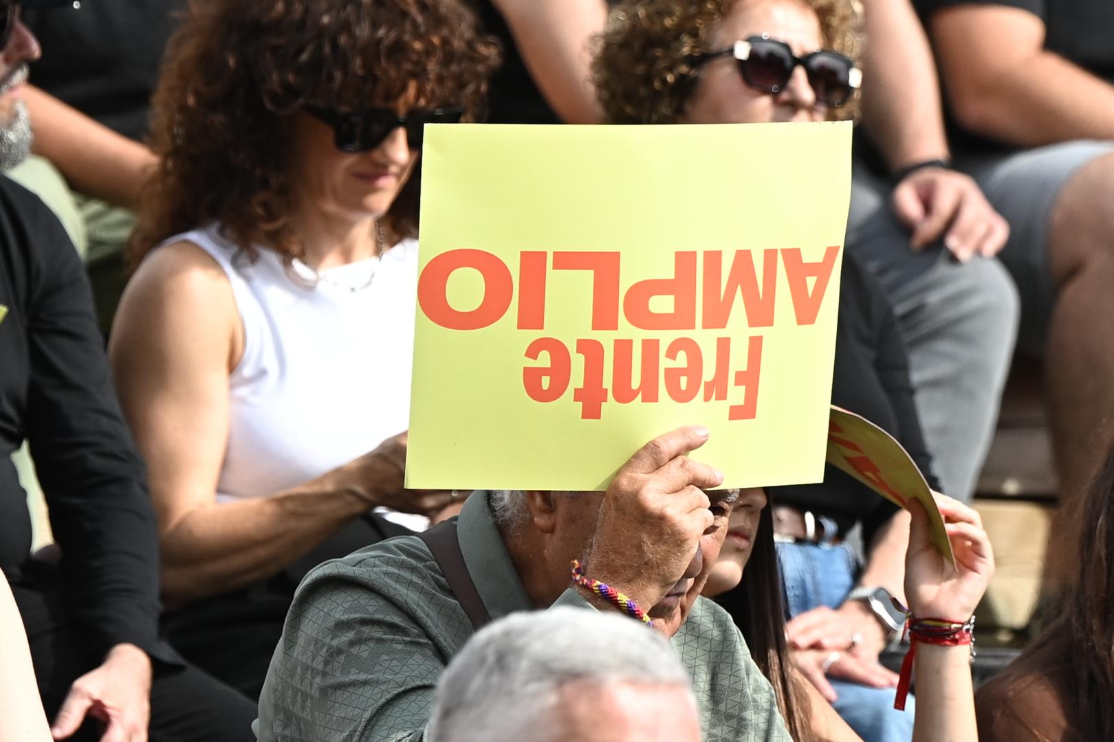 Un asistente a la presentación este sábado 17 de octubre de Frente Amplio en Madrid sujeta un cartel al revés con el nombre de la coalición