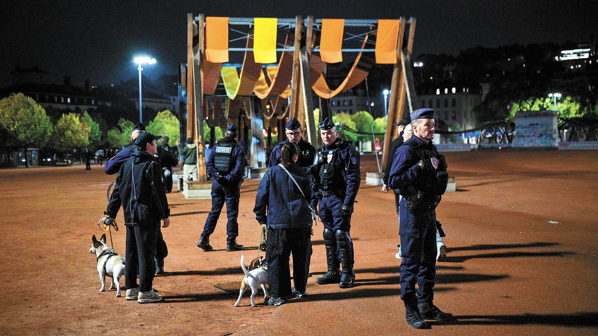 Varios policías vigilan una plaza del centro de Lyon durante el toque de queda