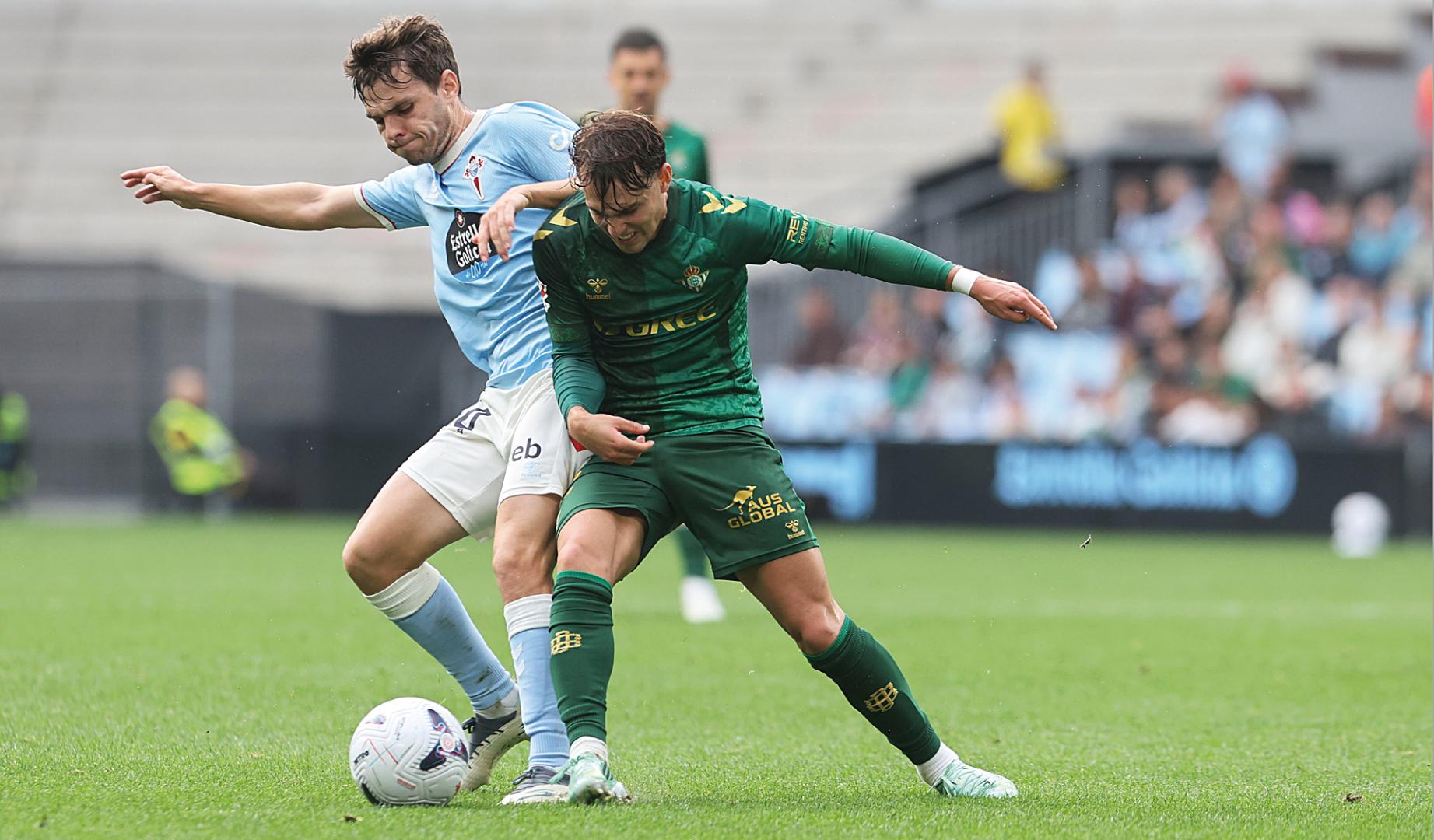 El defensa del Celta Javi Rodríguez (i) pugna por un balón con el defensa del Betis Ángel Ortiz en el partido de LaLiga disputado este domingo en el estadio de Balaidos, en Vigo