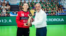 La capitana de Gurpea Beti Onak, Olaia Luzuriaga, recoge la copa de manos del presidente de la Federación Navarra de Balonmano, Andrés Garde