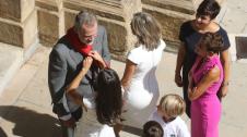 Momento en el que la reina Letizia coloca al rey Felipe VI uno de los pañuelos rojos que unos niños le habían obsequiado en la puerta del Ayuntamiento de Pamplona