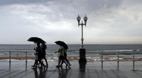 Lluvia tiempo gijón Varias personas se protegen con el paraguas de la lluvia, en el paseo de muro de la playa de San Lorenzo de Gijón