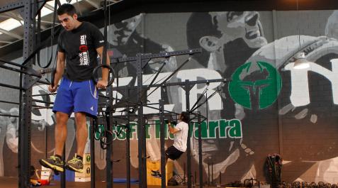 Un joven en las anillas de máquinas del entrenamiento de crossfit. Un joven en las anillas de máquinas del entrenamiento de crossfit.