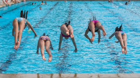 Un grupo de niñas saltando a una piscina. Un grupo de niñas saltando a una piscina.