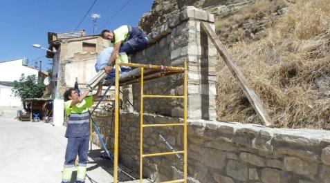 Dos de los trabajadores ultiman la construcción de un muro de piedra en Lodosa. Dos de los trabajadores ultiman la construcción de un muro de piedra en Lodosa.