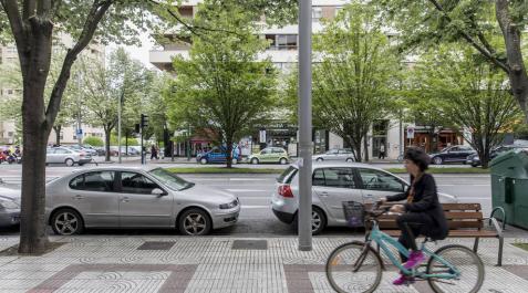 Una ciclista por la acera de Pío XII, junto al cordón de aparcamientos que se propone suprimir.