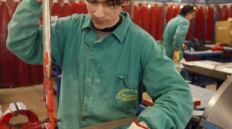 Un joven realiza un trabajo en una fábrica. Un joven realiza un trabajo en una fábrica.