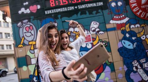 Reloj de Kukuxumusu Dos jóvenes se fotografían con el reloj de Kukuxumusu que anunciaba la cuenta atrás para San Fermín.