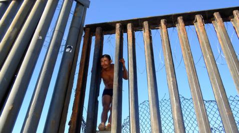 La caravana migrante llega al muro de Tijuana frontera con