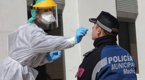 Una sanitaria realiza un test a un policía municipal de Madrid. Una sanitaria realiza un test a un policía municipal de Madrid.
