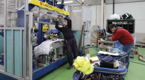Operarios de Uscal trabajan con una máquina. Operarios de Uscal trabajan con una máquina.
