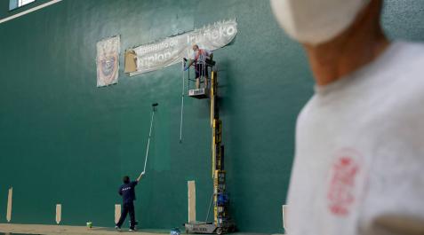 Dos operarios de la Federación Navarra de Pelota pintan la pared izquierda del Labrit este lunes por la mañana. Dos operarios de la Federación Navarra de Pelota pintan la pared izquierda del Labrit este lunes por la mañana.