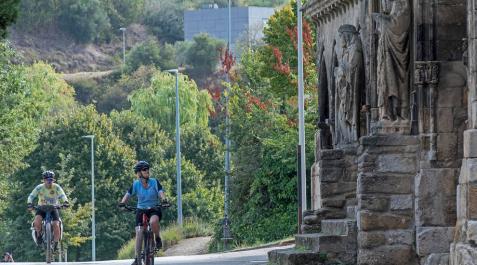 Dos personas acceden en bicicleta al entorno de Curtidores y contemplan la iglesia del Santo Sepulcro. Dos personas acceden en bicicleta al entorno de Curtidores y contemplan la iglesia del Santo Sepulcro.