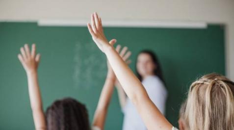 Dos niñas atienden a la profesora en una de sus clases en el colegio Dos niñas atienden a la profesora en una de sus clases en el colegio