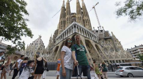 Varios turistas se fotografían frente a la Sagrada Familia en Barcelona.