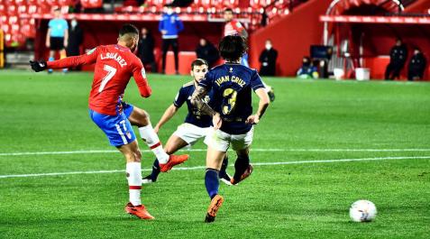 El delantero colombiano del Granada Luis Suárez golpea el balón ante dos rivales de Osasuna, El delantero colombiano del Granada Luis Suárez golpea el balón ante dos rivales de Osasuna,