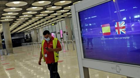 Un operario de Iberia pasa al lado de un monitor con las banderas de España y Reino Unido en la T1 del Aeropuerto de Madrid-Barajas. Un operario de Iberia pasa al lado de un monitor con las banderas de España y Reino Unido en la T1 del Aeropuerto de Madrid-Barajas.