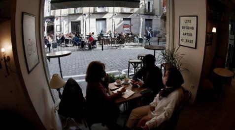 Varios clientes en el interior de una cafetería de Pamplona, con una terraza al fondo. Varios clientes en el interior de una cafetería de Pamplona, con una terraza al fondo.