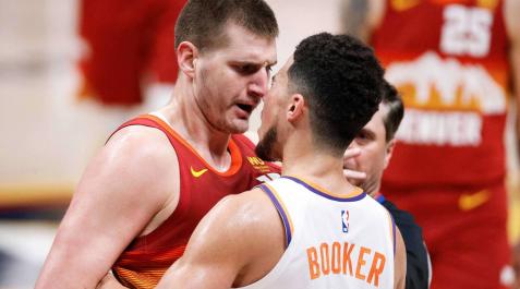 Nikola Jokic discute con Devin Booker.