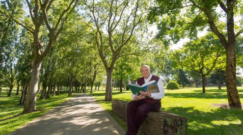 El autor Carlos Soria posa en el campus de la Universidad de Navarra con su libro