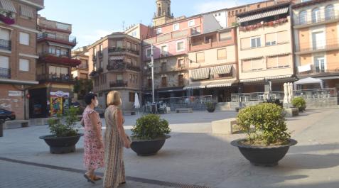 Dos vecinas pasean por la plaza de los Fueros de la localidad Dos vecinas pasean por la plaza de los Fueros de la localidad