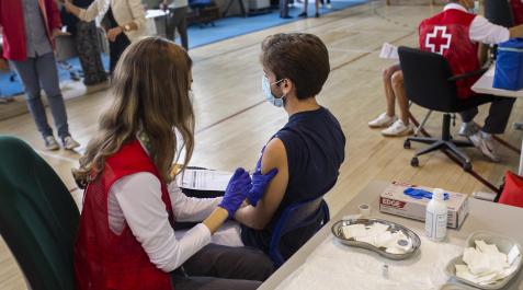 vacunación madrid Una voluntaria de Cruz Roja administra una dosis de la vacuna contra el Covid-19 a un estudiante universitario en el campus de Ciudad Universitaria