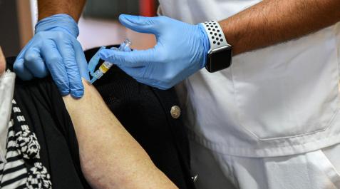 vacuna-coronavirus Una mujer recibe una dosis de la vacuna contra la gripe que se va a inocular a la vez que la tercera dosis contra la covid
