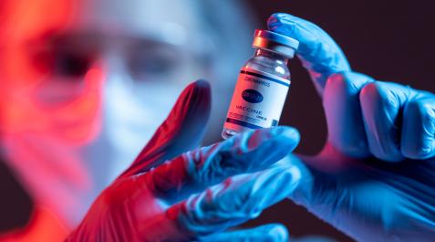 vacuna covid Una investigadora sostiene un vial de vacuna contra la covid