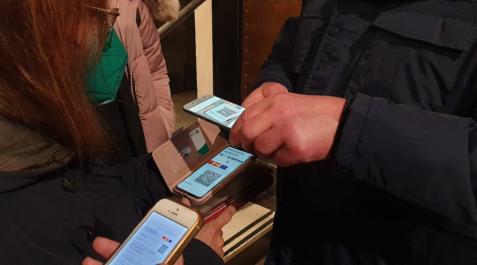 Varias personas muestran su pasaporte covid para entrar a un local Varias personas muestran su pasaporte covid para entrar a un local