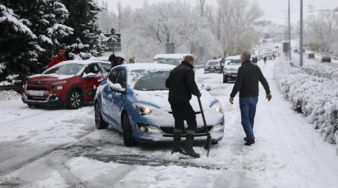 Nieve en Navarra Varias personas ayudan a los vehículos atrapados en la avenida de Navarra