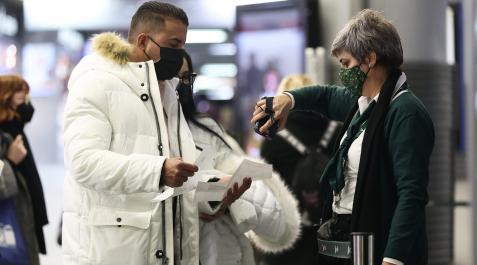 CoronaMasdrid Una empleada escanea el código de barras del billete de un pasajero, en la estación de Atocha, en Madrid