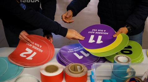 PortugalElecciones Dos voluntarios preparan carteles informativos en un colegio electoral de Lisboa