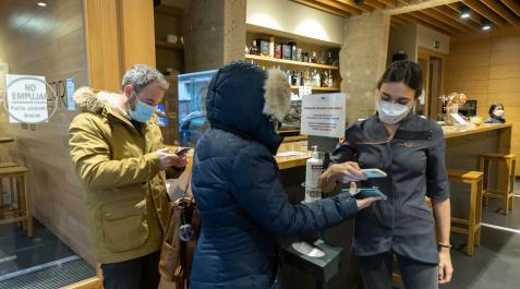 pasaporte covid Una camarera del restaurante Olaverri de Pamplona pasa el lector sobre el certificado covid que dos clientes tienen en sus teléfonos móviles