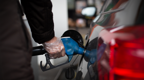 Un hombre reposta gasolina en una gasolinera Un hombre reposta gasolina en una gasolinera