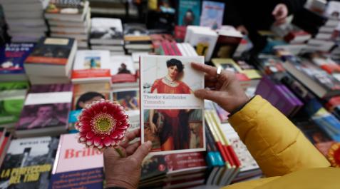 Una lectora sujeta un libro y una flor en el Día del Libro en Pamplona Una lectora sujeta un libro y una flor en el Día del Libro en Pamplona