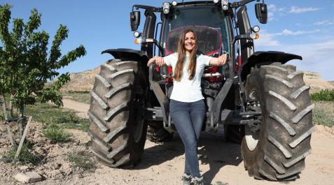 Irene Nonay posa en su campo de almendros ante su nuevo tractor