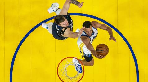NBA Luka Doncic trata de frenar la internada a canasta de Stephen Curry durante el segundo encuentro de la serie