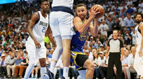 DallasWarriors Stephen Curry trata de superar la presión de dos jugadores de los Mavericks